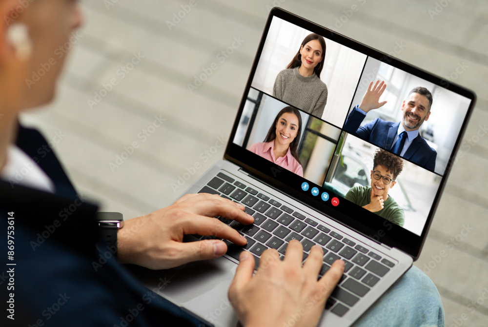 Aufkleber man sits and uses their laptop to participate in a virtual meeting with three other participants. th