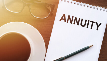 Notepad With the Word Annuity Next to a Cup of Coffee