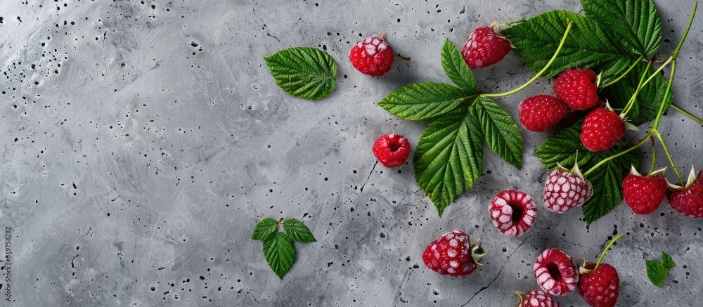 Aufkleber Design mockup featuring a ripe raspberry with green leaves on a concrete background, with space for adding an image.