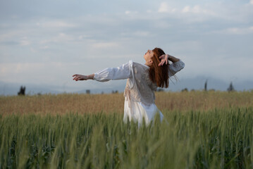 Young woman dancing outdoors. Modern dance performance in the meadow field. Carefree and freedom in nature