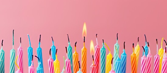 Vibrant birthday candles atop soft pink backdrop, perfect for a copy space image.