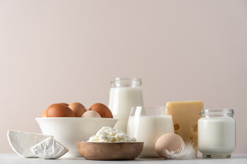 Eggs, milk, yogurt, cottage cheese, cheese side view on  beige background. Dairy farm products concept