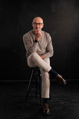 Full length of a mid aged man sitting against isolated background