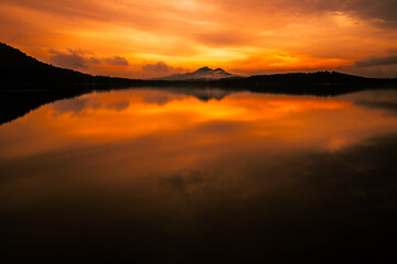 Epic sunset with reflections on the lake in north Bohemia.  Breathtaking moment when the sun paint colors across the whole sky.