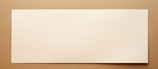 Overhead view of a blank white paper on a beige background with copy space image.
