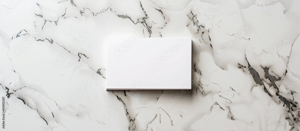 Poster top view of a business card or invitation mockup displayed on a marble table with copy space image.