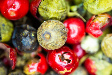 Close-up macro a vibrant mix of green, red, and black peppercorns.