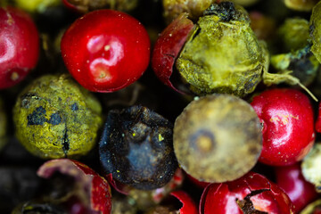 Close-up macro a vibrant mix of green, red, and black peppercorns.