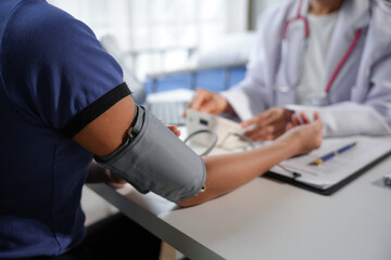 Doctor measuring blood pressure of patient in hospital room