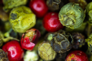 Close-up macro a vibrant mix of green, red, and black peppercorns.