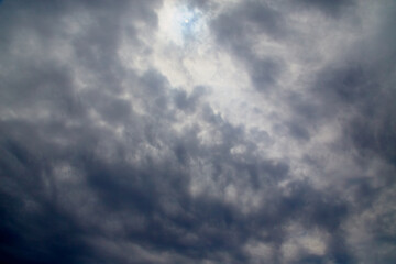 Sunlight pierces black clouds, gloomy clouds block out sunlight, dramatic mystical sky in dark colors