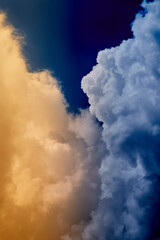 Two large clouds, warm and cold, in the sky, meeting of warm and cold fronts, change of seasons, sudden weather change, meeting of opposites