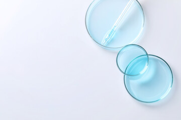 Pipette and petri dishes on white table, flat lay. Space for text