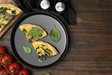 Pieces of delicious pie with spinach on wooden table, flat lay. Space for text