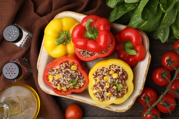 Flat lay composition with quinoa stuffed bell peppers on wooden table