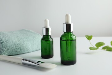 Bottles of chemical peel, towel and brush on light background. Peeling procedure