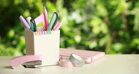 Stapler, holder and other different stationery on white table, space for text
