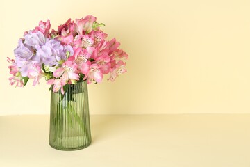 Beautiful alstroemeria flowers in vase on beige background, space for text