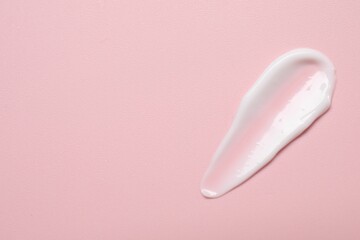 Face cream on pink background, top view. Space for text