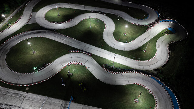 Aerial view night karting track with fast going kart cars in time lapse - Powered by Adobe