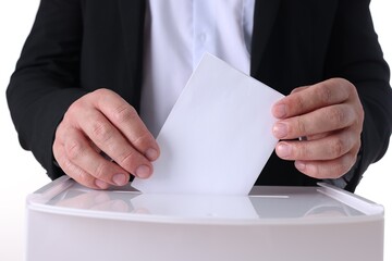 Man putting his vote into ballot box against white background, closeup