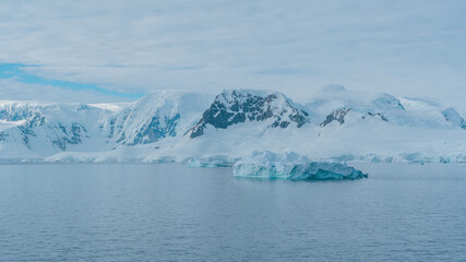 Antarctica Frozen Wonderland Landscape Serene Picture Perfect Nature Untouched Mountains Icebergs Clouds Calm Waters. Snow Covered White Peaks