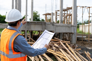 Fototapeta premium A team of construction engineers talks with managers and construction workers at the construction site. Quality inspection, plans, home and industrial building design projects
