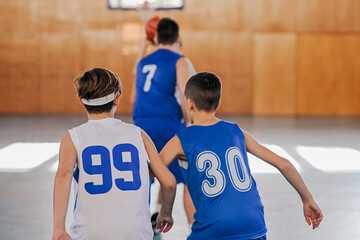 Back view of two kids watching basketball game
