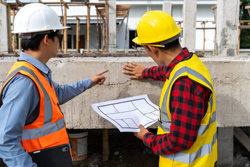 A team of construction engineers talks with managers and construction workers at the construction site. Quality inspection, plans, home and industrial building design projects