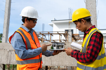 A team of construction engineers talks with managers and construction workers at the construction site. Quality inspection, plans, home and industrial building design projects