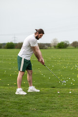 Fototapeta premium Man with golf ball on lawn for game enjoying match and competition on golfing course