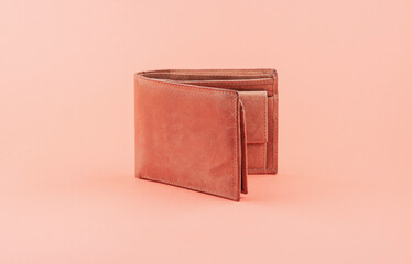 Brown leather wallet or purse on orange background.