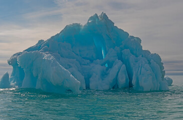 Looming Backlit Glacial Iceberg in the Ocean