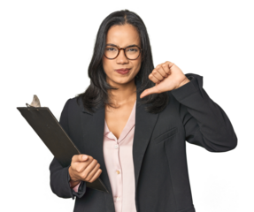 Latina businesswoman holding a report showing a dislike gesture, thumbs down. Disagreement concept.