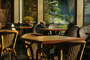 Wicker chairs and wooden tables in a cozy street cafe