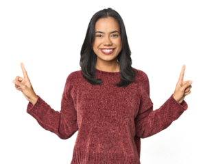 Simple portrait of a young Latina indicates with both fore fingers up showing a blank space.