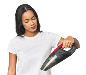 Young Latina using a vacuum cleaner in studio