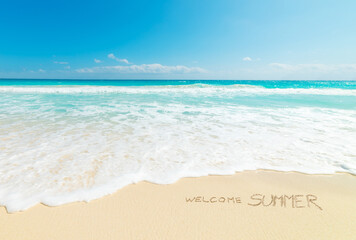 Welcome Summer written on the sand
