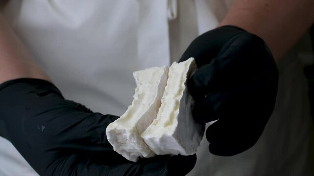 Camembert cheese. Cutting soft cheese, french brie or camembert, macro shot