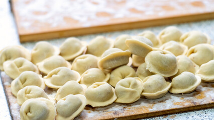Homemade dumplings close-up. handmade dumplings on a wooden board, selective focus, tinted image, traditional Russian dish,
