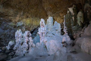 Cave interior with striking stalagmites and illuminated rock formations.