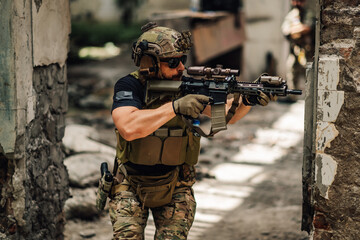 An air soft soldier in action shooting form sniper rifle in ruins.