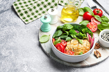 Healthy meal. Delicious chicken, vegetables and spinach served on light grey table, space for text