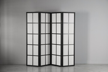 One folding screen near white wall indoors
