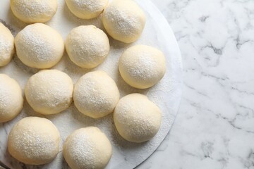 Raw dough balls on white marble table, top view. Space for text