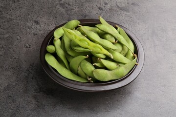 Raw green edamame pods on grey table
