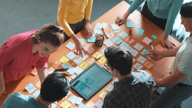 Aerial view of developer team discussing and showing digital program and writing by using Ux Ui design. Top down view of business people develop wireframe prototype for phone and computer. Symposium.