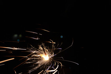 Wind blows moving to the right the sparks of fireworks illuminating New Year's Eve