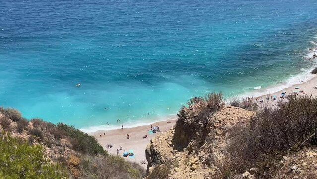 Overview on the Cala Moraig  in the Calpe area,  a stunning beach known for its crystal-clear turquoise waters, dramatic cliffs, and natural caves