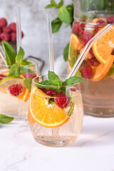 Summer Sangria cocktail or lemonade with raspberry, orange and mint. Refreshing organic non-alcoholic, Detox vitaminized healthy drink, fruit in a in a glass. Quench your thirst on a hot day.